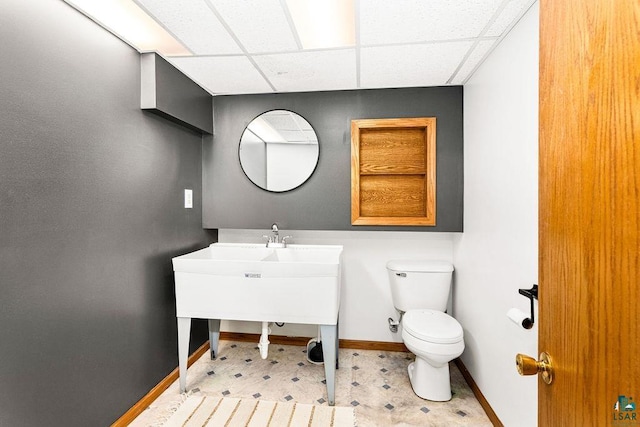 bathroom featuring vanity, baseboards, a paneled ceiling, tile patterned floors, and toilet