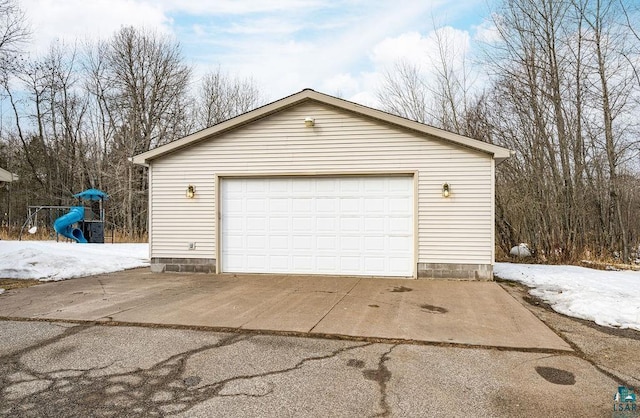 snow covered garage featuring a detached garage