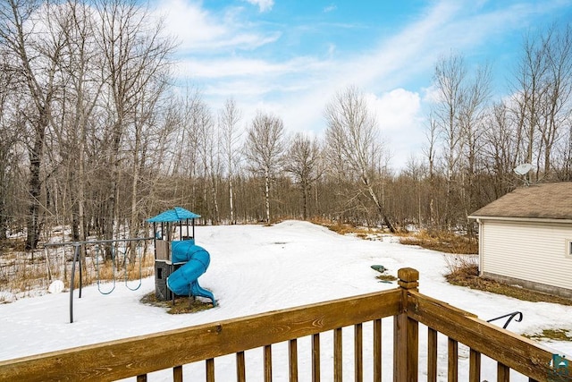 snowy yard featuring a playground