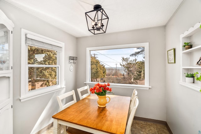 dining room with a chandelier, a healthy amount of sunlight, and baseboards