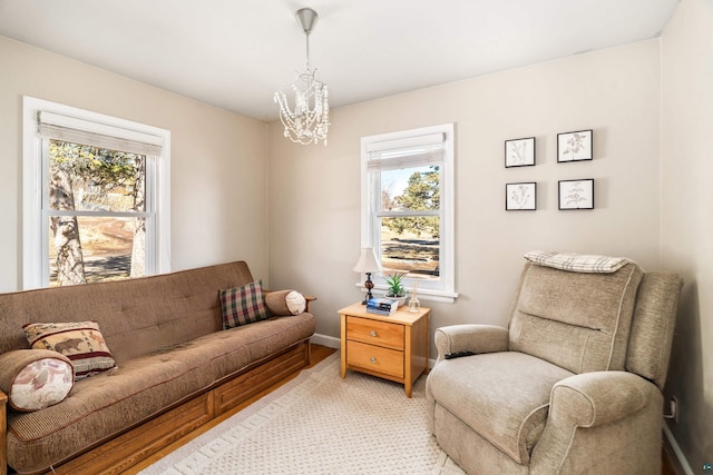 living area featuring a chandelier and baseboards