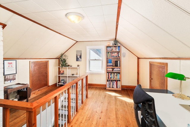 office with light wood-style flooring, baseboards, and lofted ceiling