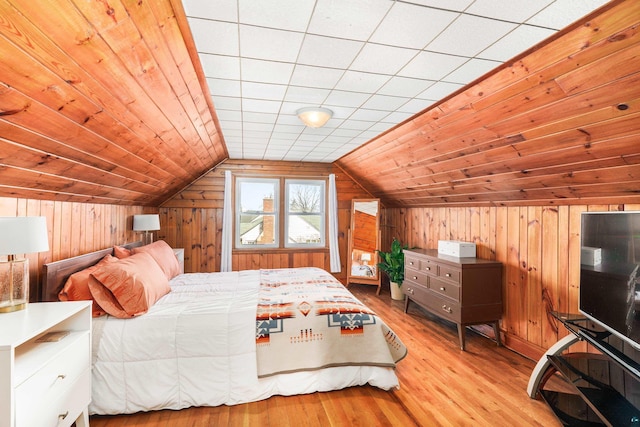 bedroom featuring vaulted ceiling, wood walls, wooden ceiling, and wood finished floors