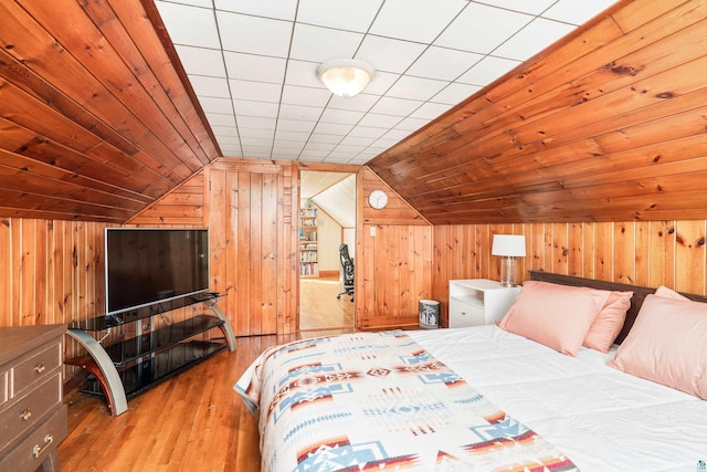 bedroom with wood-type flooring, wooden walls, wood ceiling, and vaulted ceiling