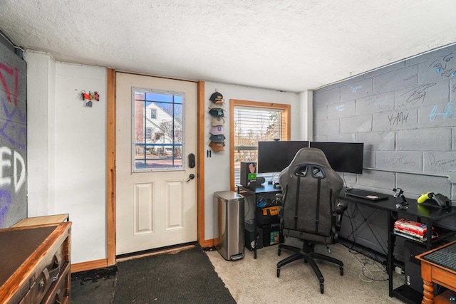 office space with concrete block wall, baseboards, and a textured ceiling