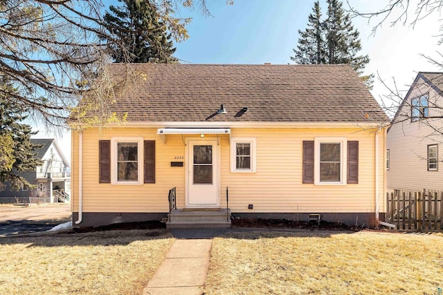 view of front of home featuring fence, roof with shingles, entry steps, a front lawn, and crawl space