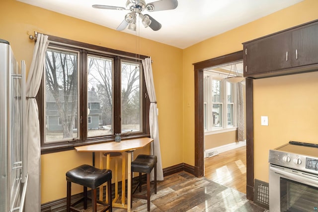 kitchen with visible vents, a ceiling fan, wood finished floors, appliances with stainless steel finishes, and baseboards