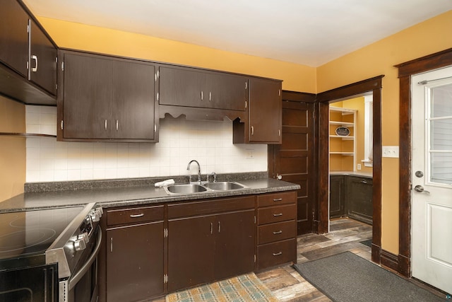 kitchen with a sink, electric range, tasteful backsplash, and dark brown cabinetry