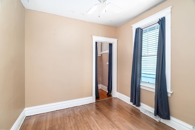 empty room with plenty of natural light, light wood-style flooring, and baseboards