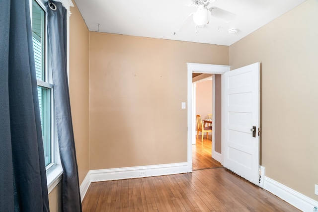 unfurnished room with ceiling fan, baseboards, and hardwood / wood-style flooring