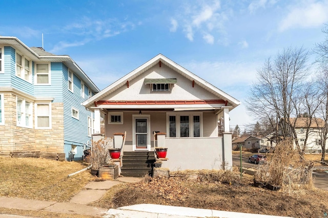 view of front of house with stucco siding and a porch