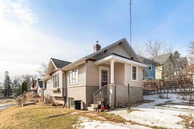 view of front of home featuring a chimney and fence