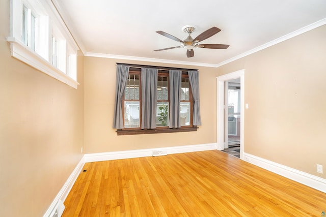 spare room with visible vents, crown molding, baseboards, ceiling fan, and wood finished floors