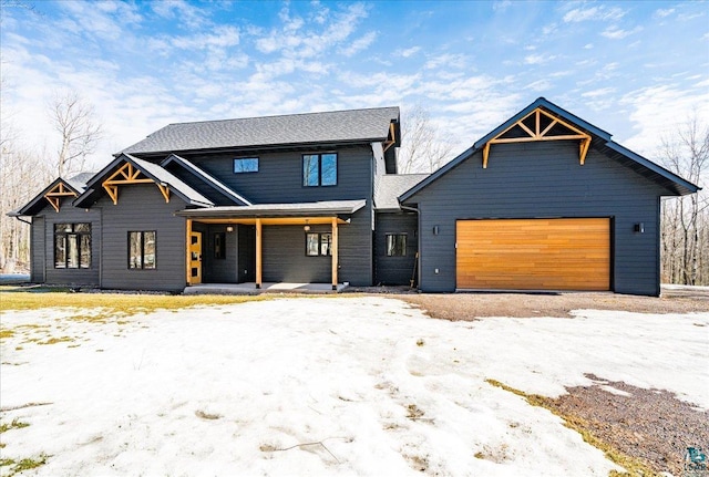 modern farmhouse featuring covered porch and an attached garage