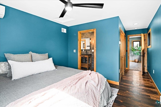 bedroom with visible vents, baseboards, wood finished floors, and a wall mounted AC