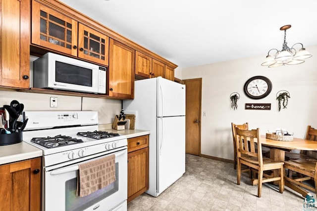 kitchen featuring glass insert cabinets, white appliances, brown cabinetry, and light countertops