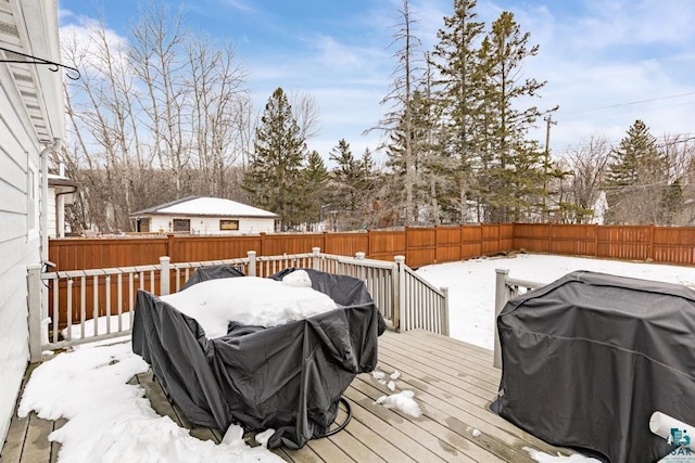 snow covered deck featuring a grill and a fenced backyard