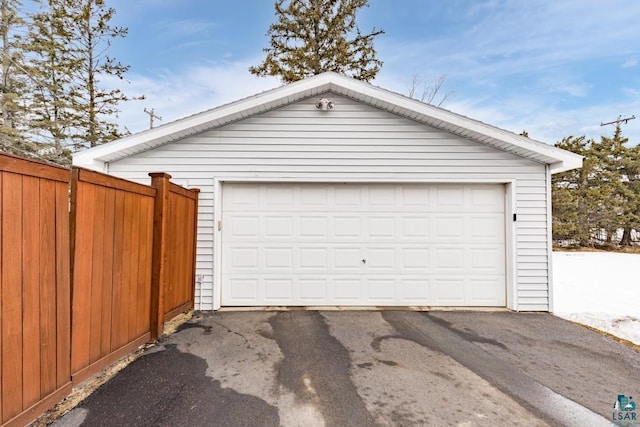 detached garage featuring fence