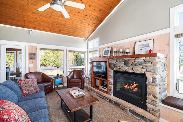 living area featuring a stone fireplace, wood ceiling, ceiling fan, and high vaulted ceiling