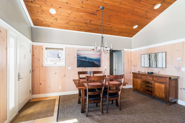 dining room featuring wooden ceiling, crown molding, wood walls, and a chandelier