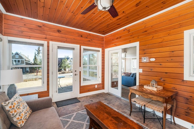 doorway with wooden ceiling, wooden walls, and a ceiling fan