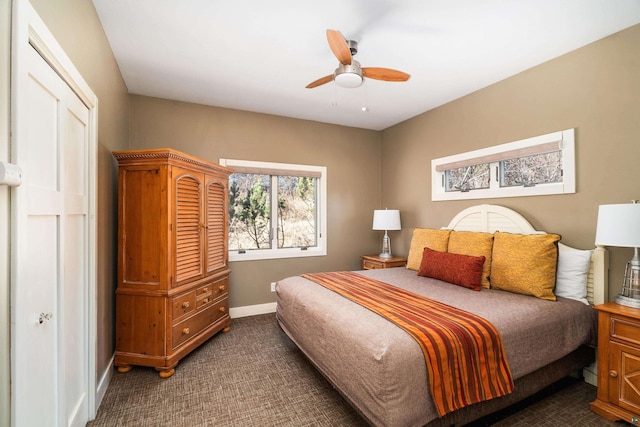 bedroom with a ceiling fan, baseboards, and dark carpet