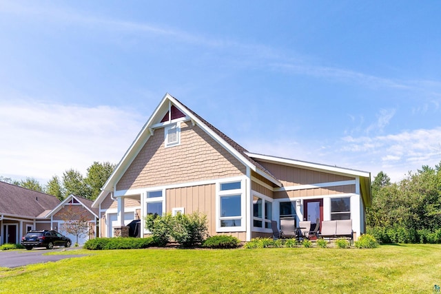 view of front of house with a garage, a front yard, and a sunroom