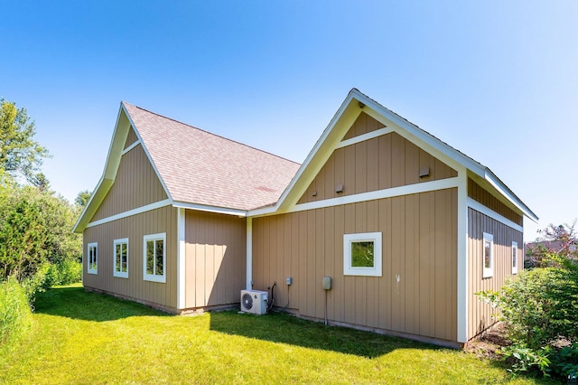 back of property with ac unit, a yard, and roof with shingles