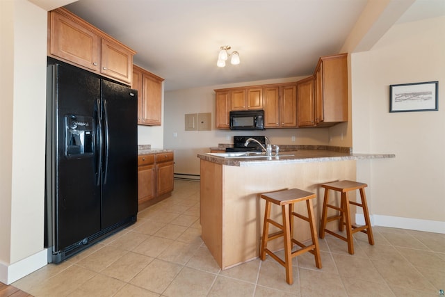 kitchen featuring a peninsula, baseboards, a sink, black appliances, and light tile patterned floors