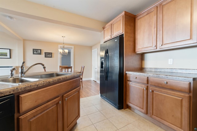 kitchen with a sink, a chandelier, black fridge, dishwashing machine, and light tile patterned floors