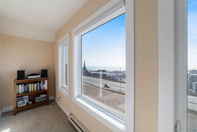 interior space with baseboards, carpet floors, vaulted ceiling, and a baseboard radiator