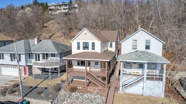 view of front of property with a residential view, a shingled roof, a patio, and stairway