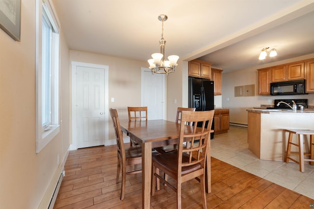 dining space featuring baseboards, baseboard heating, light wood-style floors, and a chandelier