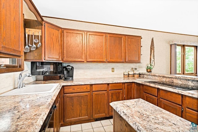 kitchen with backsplash, a sink, light stone countertops, brown cabinetry, and light tile patterned floors