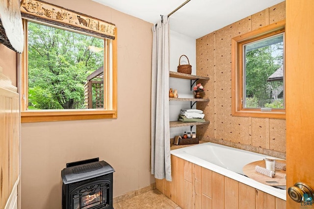 bathroom with a bath and a wood stove