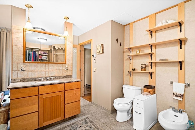 bathroom featuring vanity, toilet, tile patterned flooring, and a bidet
