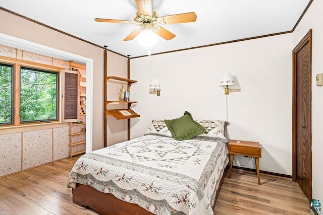 bedroom with wood finished floors, ornamental molding, and a ceiling fan