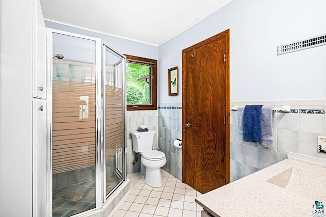 bathroom with visible vents, toilet, vanity, a stall shower, and tile patterned flooring