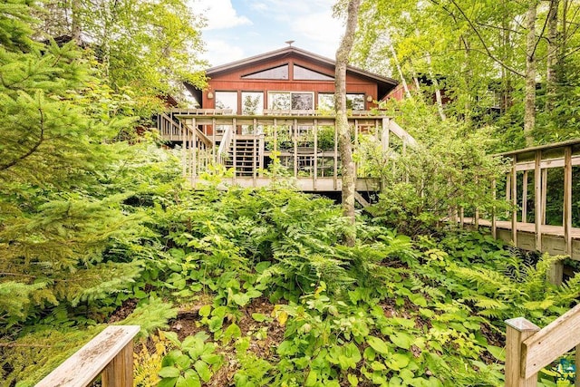 back of house featuring a wooden deck and stairway