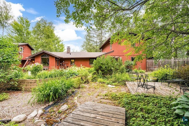 back of property featuring a chimney and fence