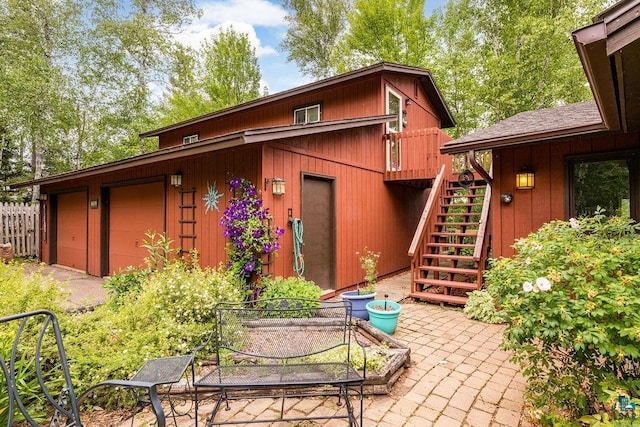 back of house featuring a garage, stairs, and a patio