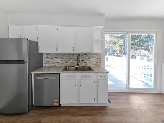 kitchen with open shelves, stainless steel appliances, decorative backsplash, dark wood finished floors, and a sink