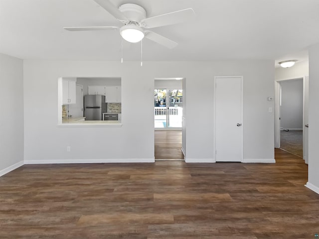 unfurnished living room featuring a ceiling fan, baseboards, and dark wood finished floors
