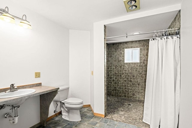 601 13th Ave, Two Harbors, MN 55616 - bathroom with a sink, toilet, tiled shower, and baseboards