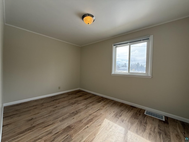 1923 W 6th St, Ashland, WI 54806 - empty room featuring visible vents, baseboards, ornamental molding, and wood finished floors