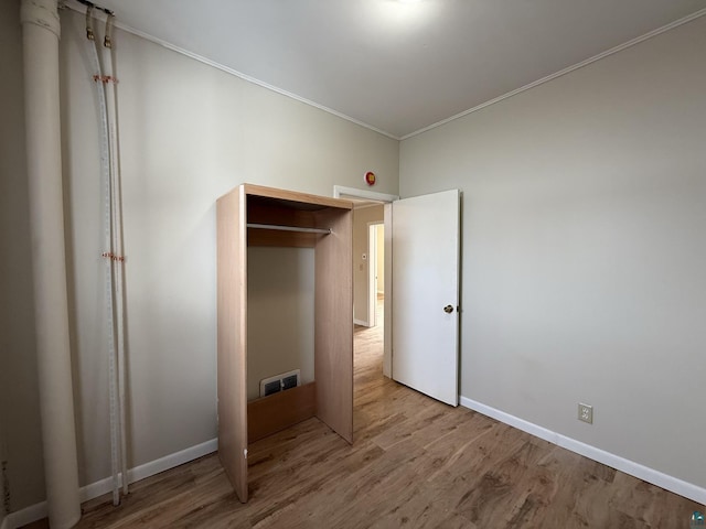 1923 W 6th St, Ashland, WI 54806 - unfurnished bedroom with wood finished floors, baseboards, ornamental molding, and visible vents