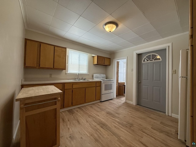 1923 W 6th St, Ashland, WI 54806 - kitchen featuring light wood-type flooring, white appliances, light countertops, brown cabinets, and a sink