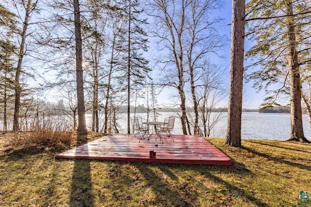 view of community featuring a yard and a deck with water view