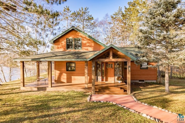 chalet / cabin featuring a front yard and stone siding