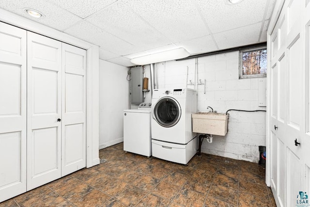 washroom with a sink, independent washer and dryer, laundry area, and concrete block wall